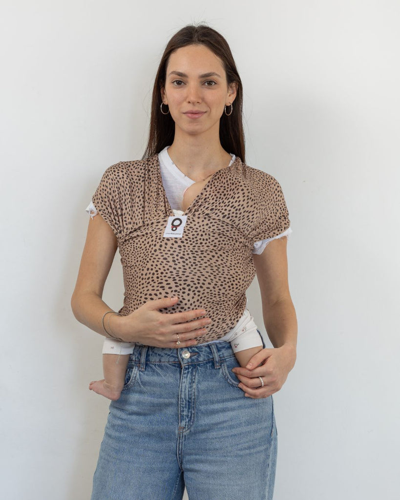 אישה עם תינוק במנשא קשירה מבד מגיל לידה מבד  מודל מדגם ציטה בצבע חול עם הדפס של מנומר וחברבורות של חברת אורבן בייבי 