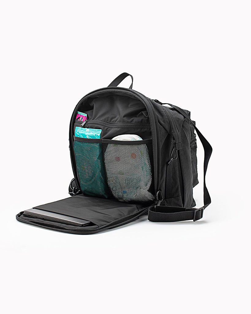 תמונת פק שוט של תיק החתלה גדול  בעיצוב נקי עשוי ניילון שחור ממוחזר של חברת וואן דואו one duo. התמונה מראה את חלוקת התאים הפנימית של התא האחורי בו יש מקום ללפטופ , תא למגבונים, תא לחיתולים, וכיס עם ריצרץ 