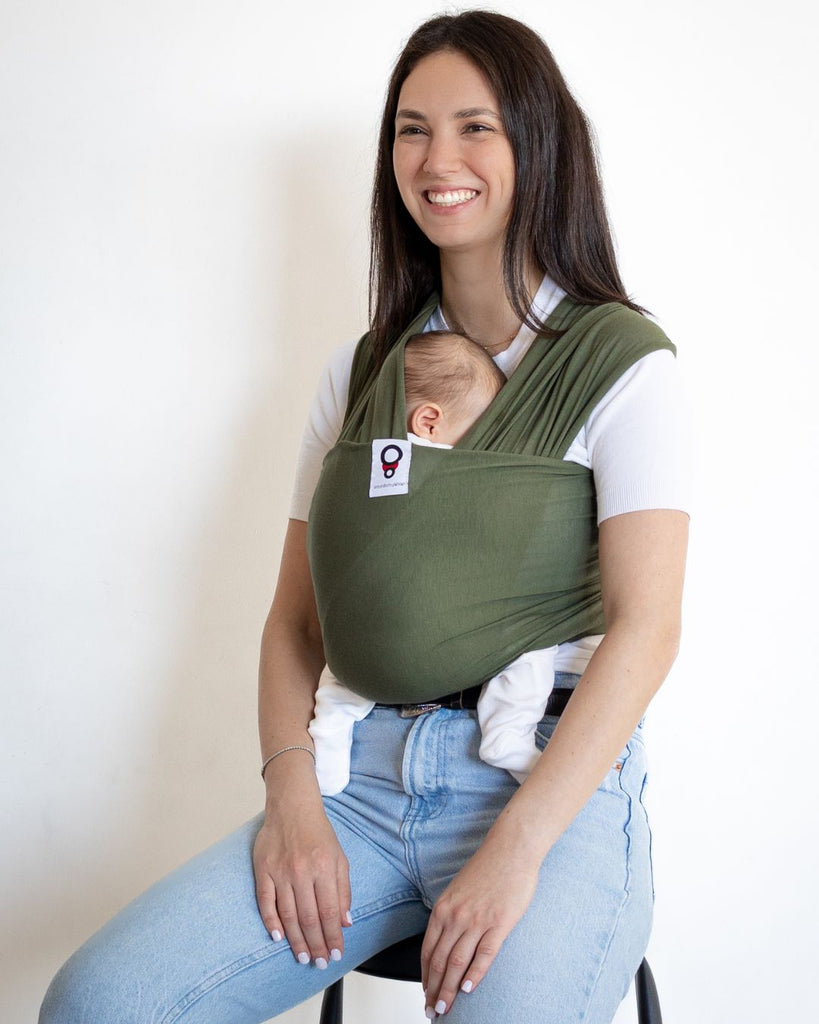 אישה גבוהה נושאת את התינוק שלה במנשא בד בצבע ירוק מבד מודל דק ונושם מגיל לידה