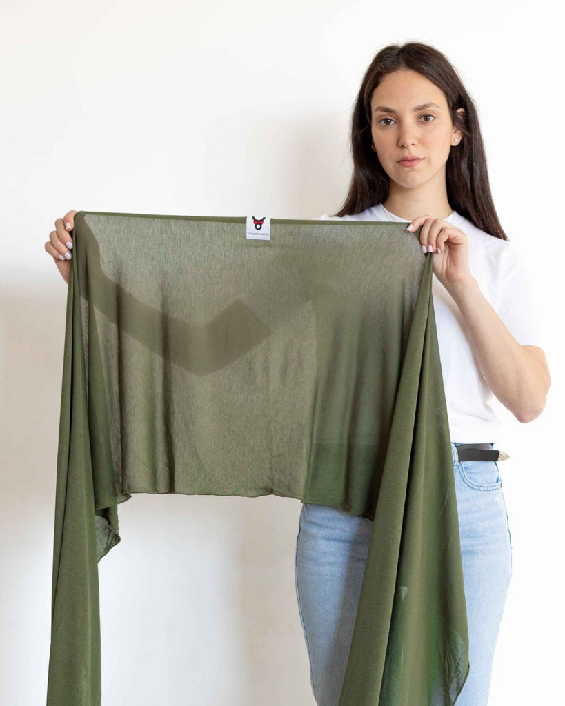 דוגמנית מחזיקה מנשא בד דק לקיץ מבד מודל בצבע ירוק שמתאים לתינוקות מגיל לידה