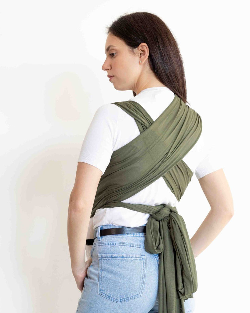 אישה גבוהה נושאת את התינוק שלה במנשא בד בצבע ירוק מבד מודל דק ונושם מגיל לידה