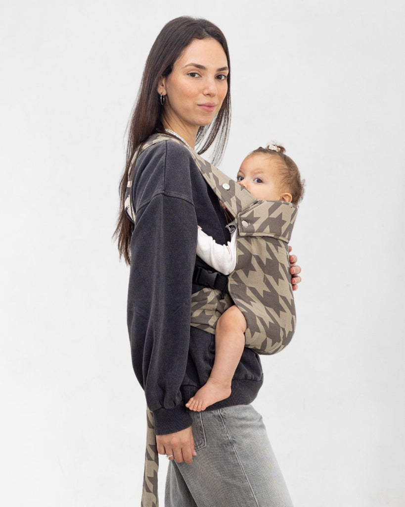 דוגמנית עם תינוק במנשא מגיל לידה של חברת אורבן בייבי ראפ בצבע בז עם הדפס פפיטה